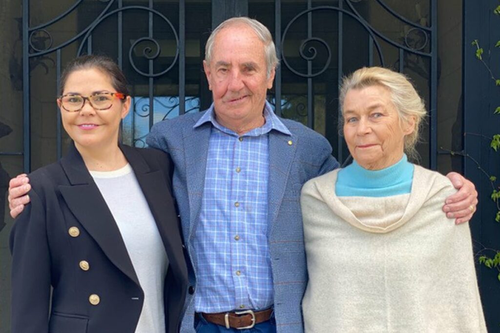 A man standing with his arms around two women