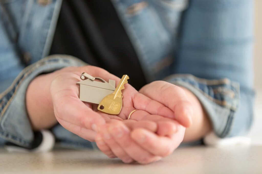 hands clasped holding a house key