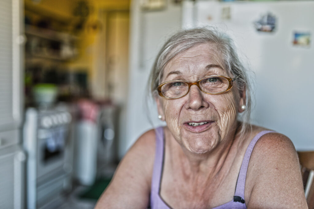 woman sitting inside home, smiling