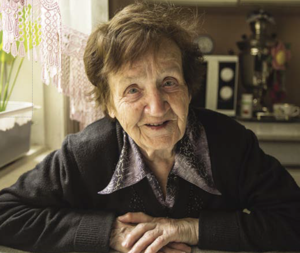 Elderly woman sitting with hands clasped