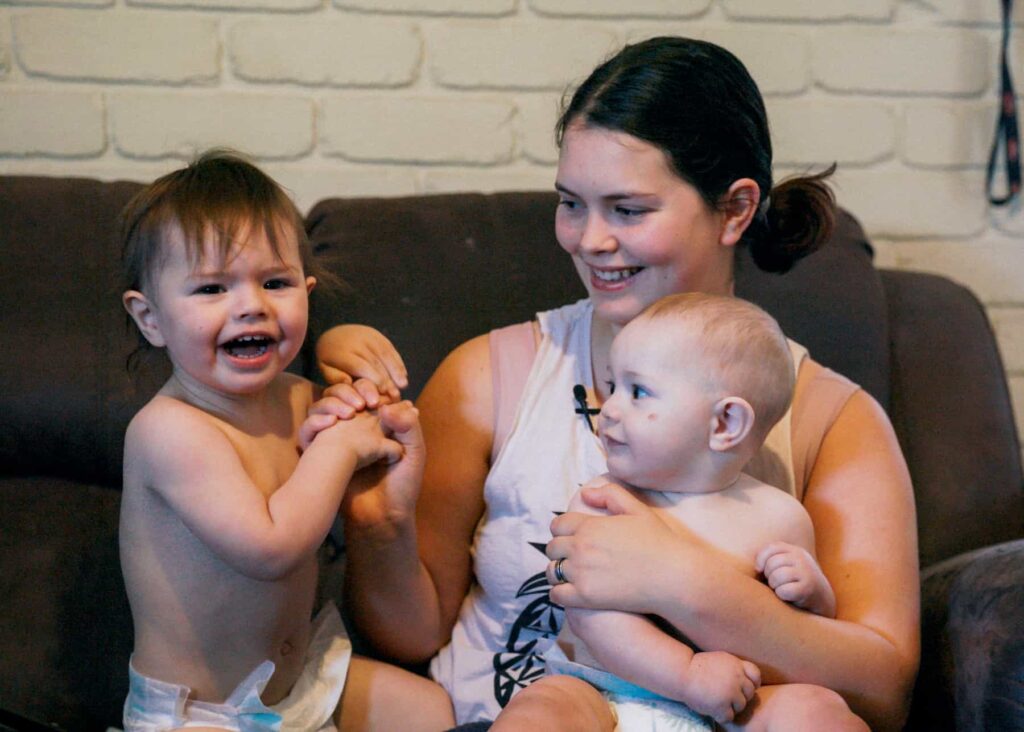 mother and two children sitting on a couch smiling